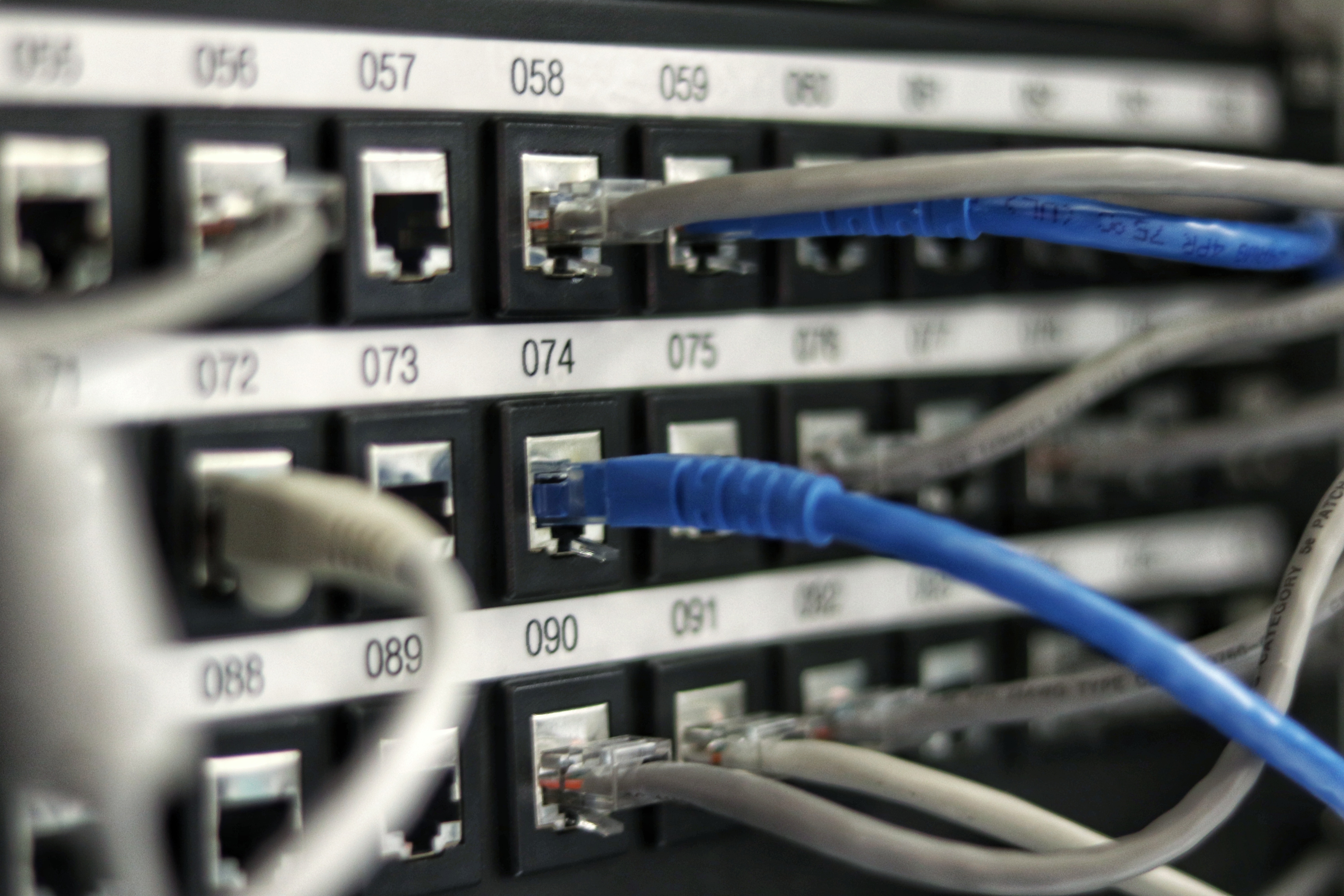 Switch gerenciável em rack corporativo com cabos organizados e identificados, sala de servidores de empresa no Rio de Janeiro
